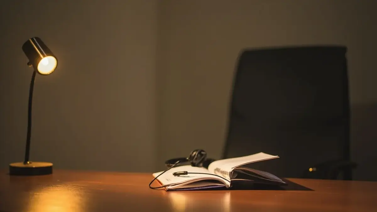 Editorial photography of a customer support desk at a small Indian office with a single headset resting on a closed notebook